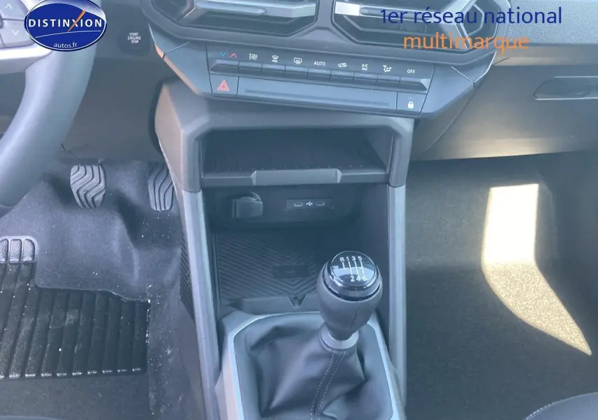 Vue rapprochée de la console centrale du Dacia Duster gris schiste 2026, avec levier de vitesse manuel et commandes clim.