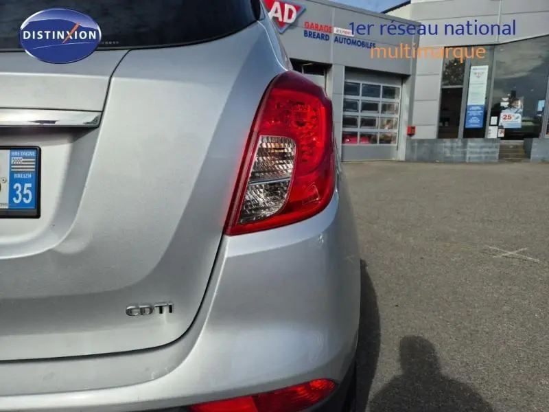 Vue arrière droite d'un Opel Mokka X gris minéral avec feux arrière et badge CDTI visibles.