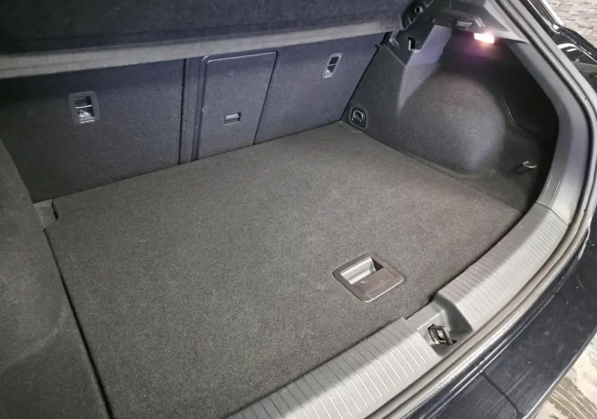 Coffre ouvert du Volkswagen T-Roc noir 2023, vue intérieure montrant un espace de rangement propre et bien fini.