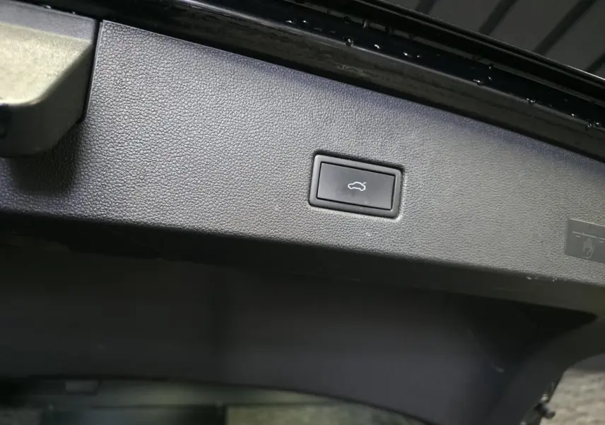 Bouton d'ouverture électrique du hayon sur la partie intérieure du coffre du Volkswagen T-Roc noir 2023.