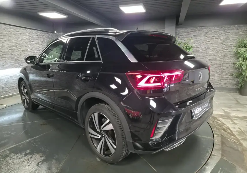 Volkswagen T-Roc noir en 3/4 arrière droit, avec feux LED allumés et jantes alliage Nevada 18 pouces.