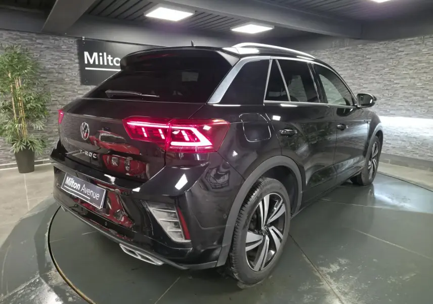Volkswagen T-Roc noir en 3/4 arrière droit, avec feux arrière LED allumés et jantes alliage Nevada 18 pouces.