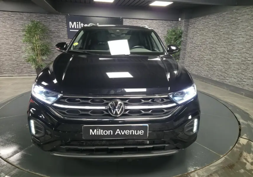 Vue frontale d'un Volkswagen T-Roc noir 2023 avec calandre R-Line et phares Matrix LED allumés.
