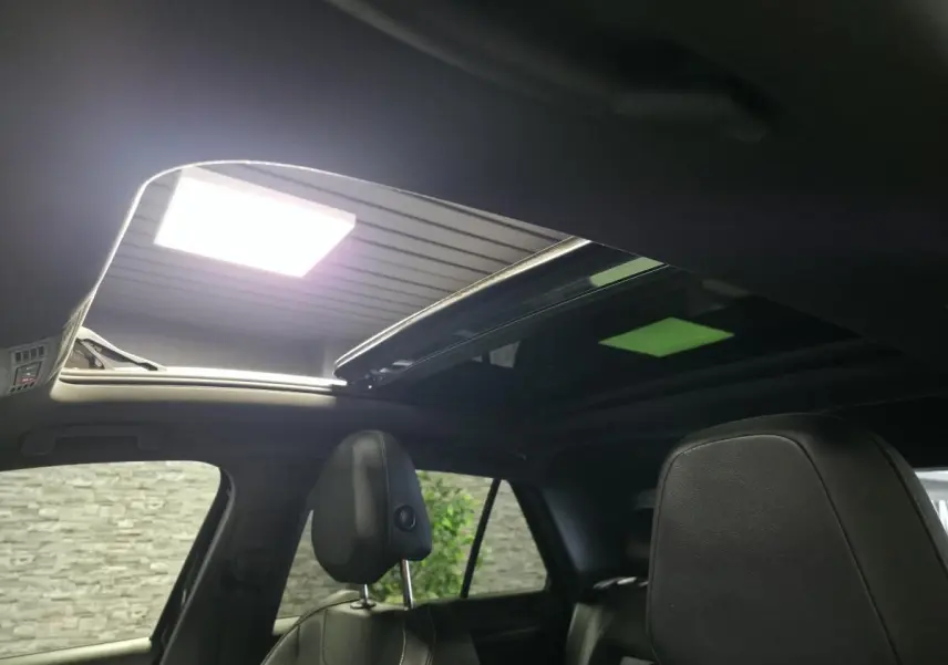 Vue intérieure du toit ouvrant en verre du Volkswagen T-Roc noir 2023 avec sièges avant en cuir noir.