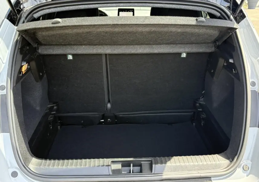 Coffre ouvert vu de l'arrière d'un Renault Captur TCE 90 Techno gris Rafale, montrant l'espace de chargement vide.