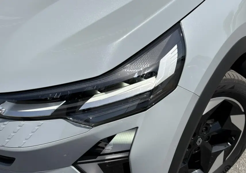Gros plan sur le phare avant gauche et la roue noire du Renault Captur Gris Rafale 2025, détail LED Pure Vision.