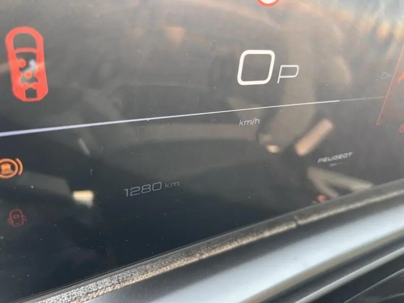 Détail du tableau de bord numérique du Peugeot 5008 Hybrid blanc, affichant 1280 km au compteur.
