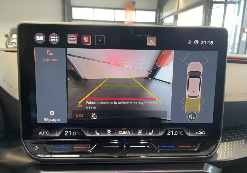 Écran tactile intérieur du CUPRA Leon 2026 montrant la caméra de recul et les réglages de climatisation à 21°C.