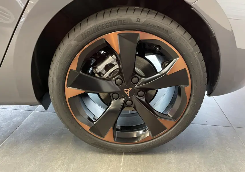Gros plan sur la jante avant droite cuivrée et noire de la CUPRA Leon gris magnétique avec logo central distinctif.