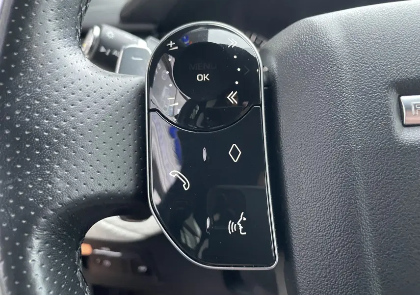 Gros plan sur les commandes tactiles noires à gauche du volant perforé du Range Rover Velar Silicon Silver 2018.