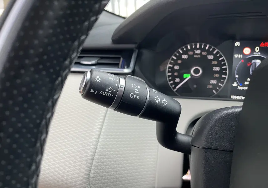 Gros plan sur la commande des feux et clignotants du Range Rover Velar 2018, intérieur noir et beige.