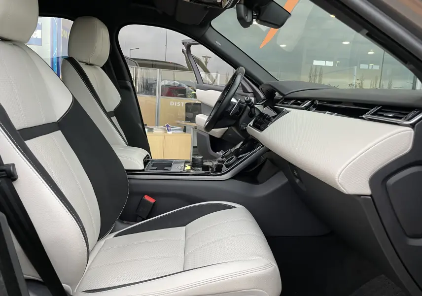 Intérieur du Range Rover Velar D300 2018 vu côté passager, sièges cuir beige et noir avec tableau de bord clair et moderne.