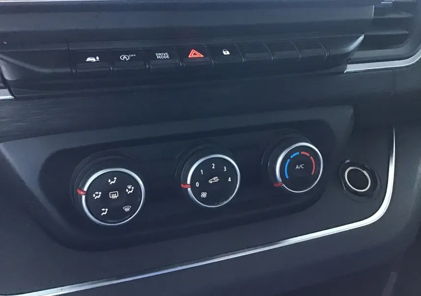 Gros plan sur les commandes de climatisation noires du tableau de bord du Nissan Primastar Fourgon blanc 2022.
