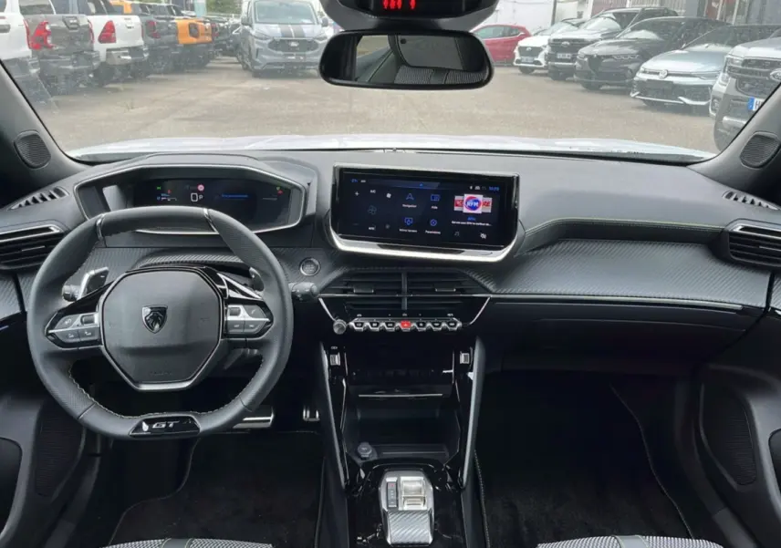Vue intérieure du tableau de bord du Peugeot 2008 Hybrid 145 GT Vision 2025 avec volant compact et écran tactile central.