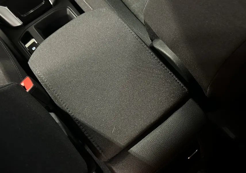 Gros plan sur l'accoudoir central en tissu noir de l'intérieur du Volkswagen T-Roc TSI 150 DSG Life 30 Years.