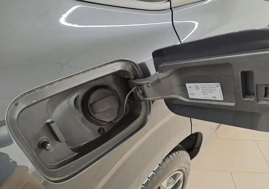 Gros plan sur la trappe à carburant côté gauche d'une CUPRA TERRAMAR gris Timanfaya avec jante 19'' visible.