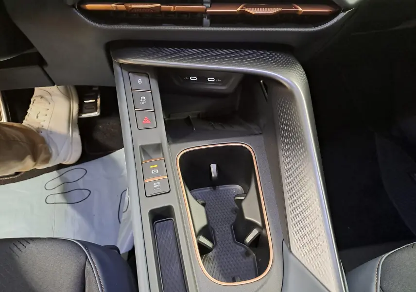 Vue plongeante sur la console centrale noire du CUPRA TERRAMAR avec inserts cuivrés et commandes tactiles.