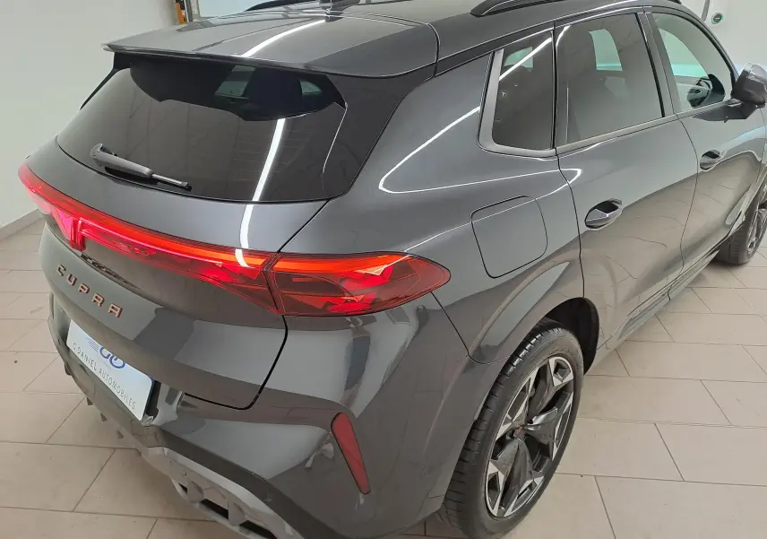 Vue 3/4 arrière droite du CUPRA TERRAMAR 2025 en gris Timanfaya avec jantes 19'' Cosmic usinées et feux arrière allumés.