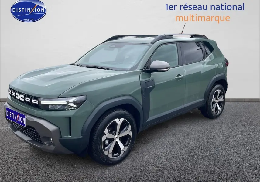 SUV Dacia Duster vert kaki en 3/4 avant droit, avec jantes alu et barres de toit visibles.