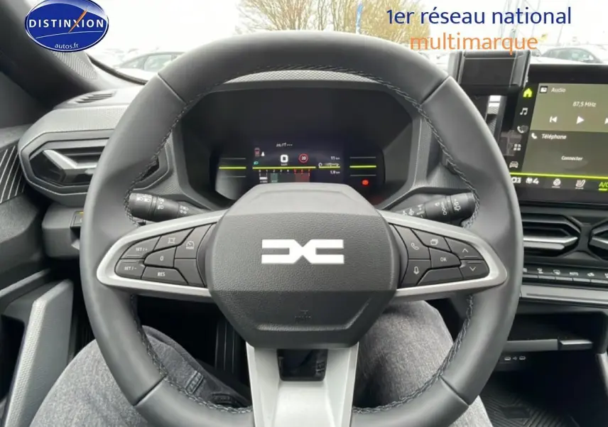 Vue intérieure centrée sur le volant multifonction du Dacia Duster 2026 avec écran tactile et tableau de bord numérique.