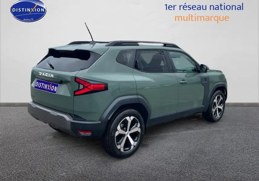 Vue 3/4 arrière droite d'un Dacia Duster 2026 vert kaki avec jantes alliage et barres de toit noires.