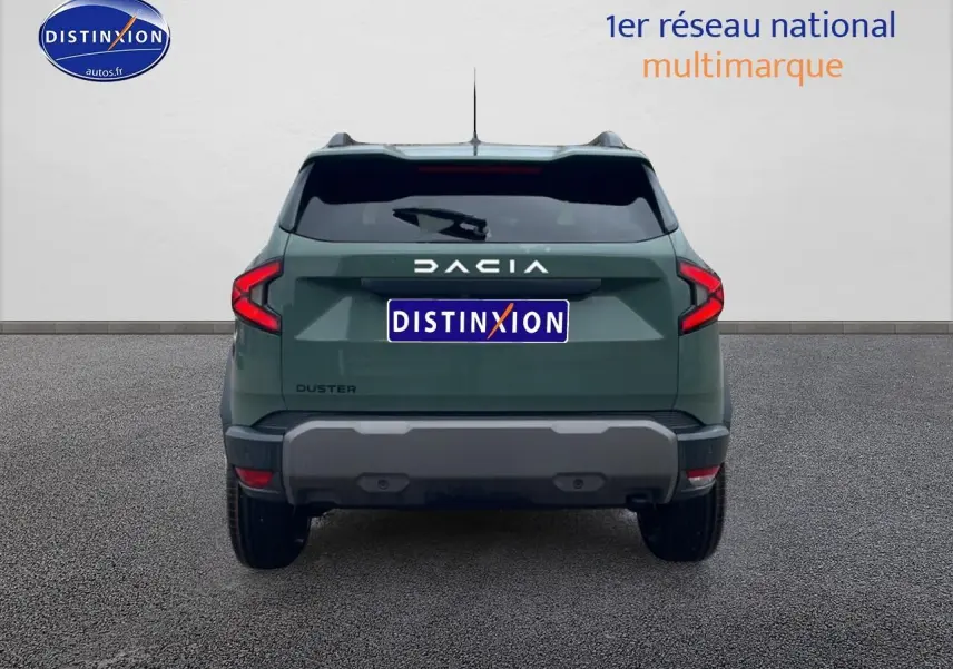 Vue arrière d'un Dacia Duster vert kaki 2026 avec feux LED et barres de toit visibles sur fond neutre.