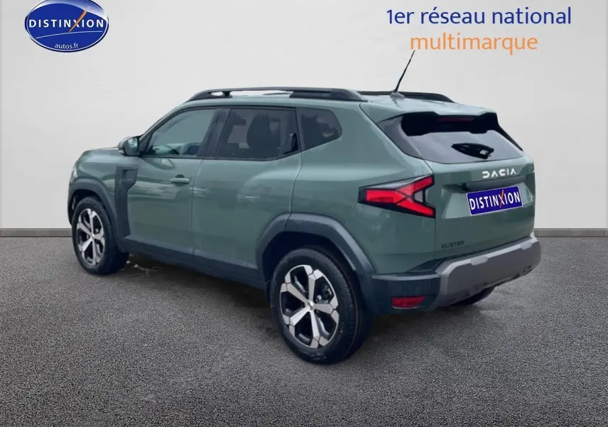 Vue 3/4 arrière droite d'un Dacia Duster vert kaki avec barres de toit et jantes alu distinctives.