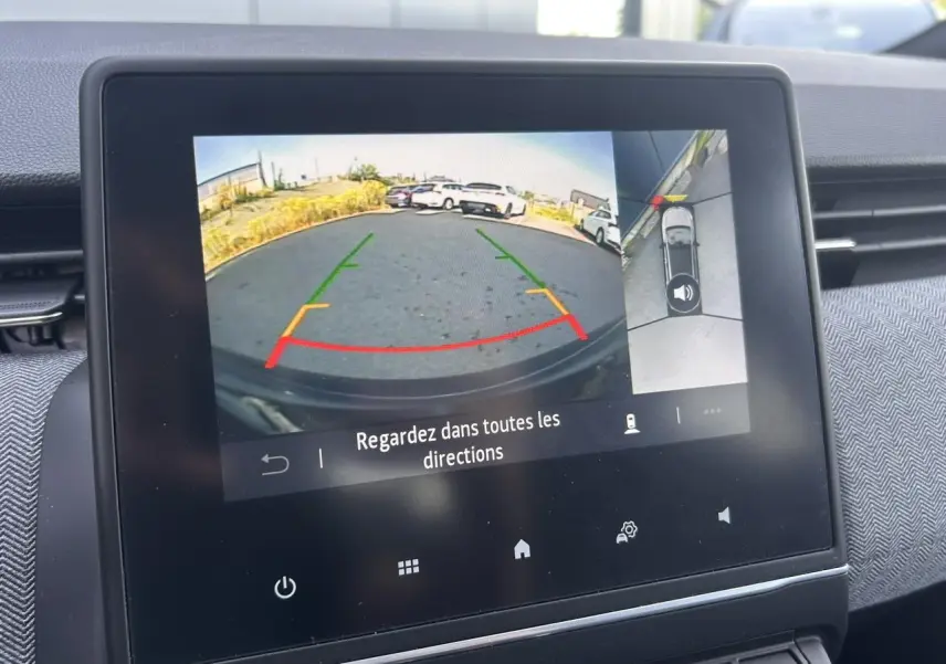 Écran multimédia montrant la caméra 360° en mode recul avec guidage coloré dans un Renault Clio noir étoilé.