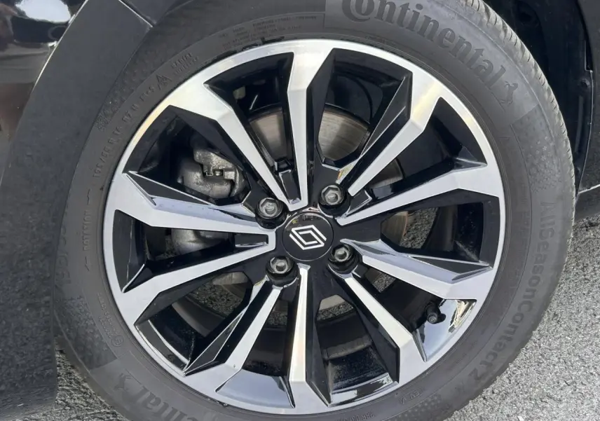 Gros plan sur la jante alliage diamantée noire et argentée de la Renault Clio 2025 avec pneu Continental AllSeason.