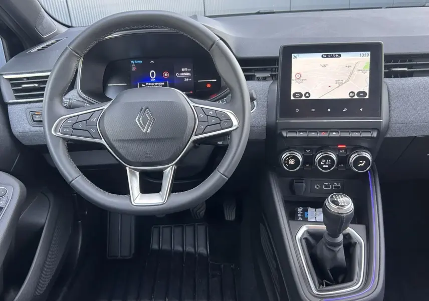 Vue intérieure frontale du tableau de bord de la Renault Clio noir étoilé avec volant multifonction et écran tactile central.