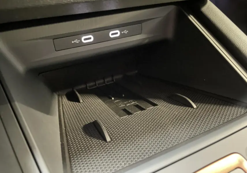 Gros plan sur la zone de recharge avec deux ports USB-C illuminés dans l’habitacle noir du CUPRA Leon 2026.