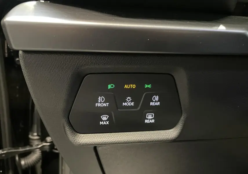 Panneau de commandes d’éclairage intérieur noir avec indicateurs verts et orange dans une CUPRA Leon 2.0 TDI noire.