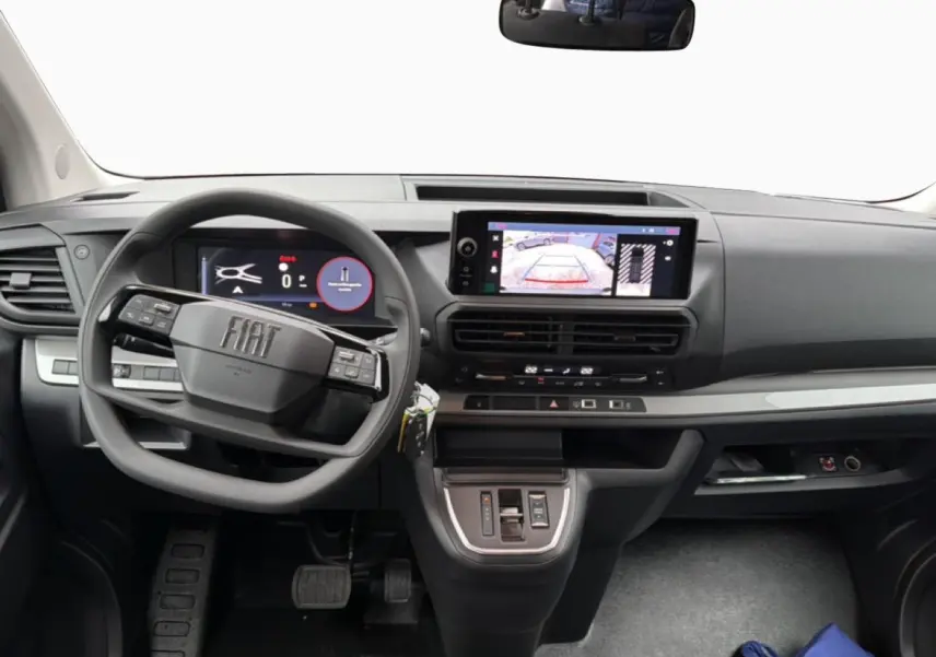 Vue intérieure avant du tableau de bord gris foncé du Fiat Scudo Combi 2026 avec écran tactile et volant multifonctions.