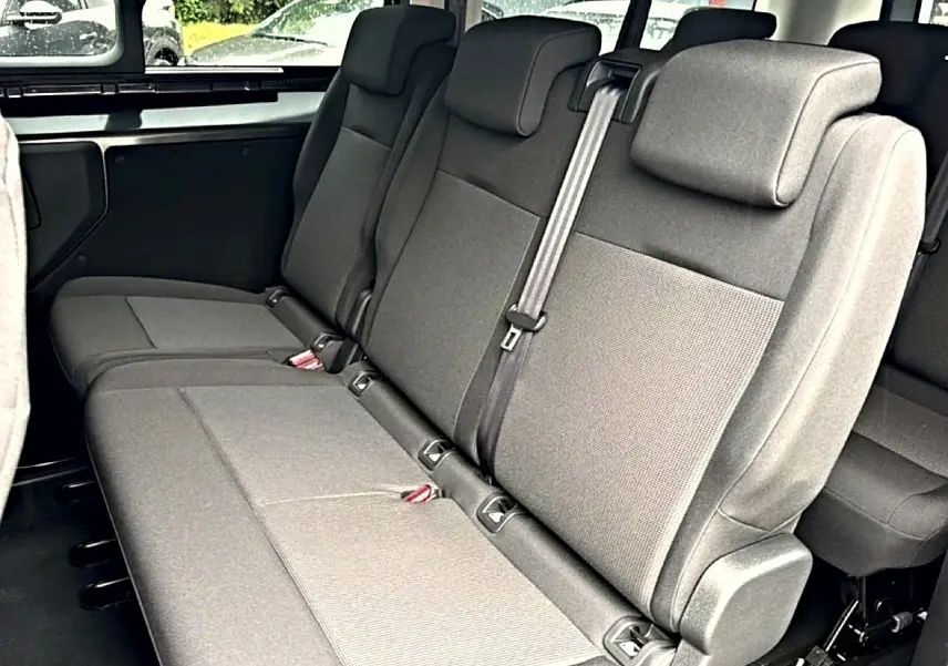 Vue intérieure sur la banquette arrière 3 places gris foncé du Fiat Scudo Combi XL 2026 avec appuie-têtes et ceinture centrale.