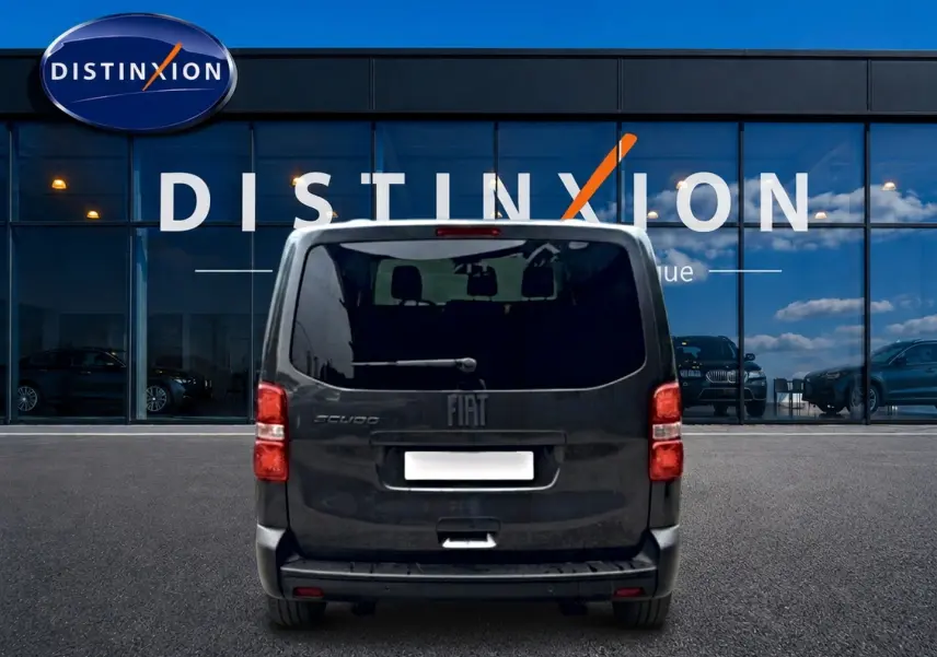 Vue arrière du FIAT Scudo Combi gris titane, porte latérale coulissante visible, stationné devant une vitrine Distinxion.