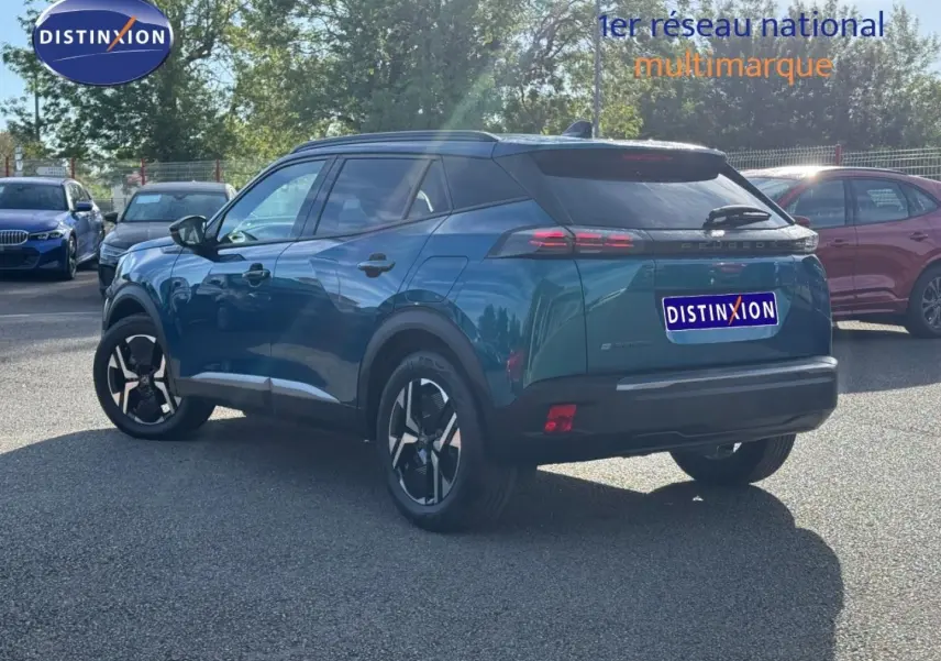 Vue 3/4 arrière droite du Peugeot e-2008 2025 en Bleu Obsession, avec jantes alu et feux arrière LED distinctifs.