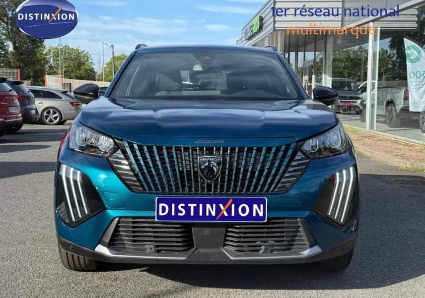 Vue frontale d’un Peugeot 2008 e-2008 bleu Obsession avec calandre verticale et feux LED distinctifs.