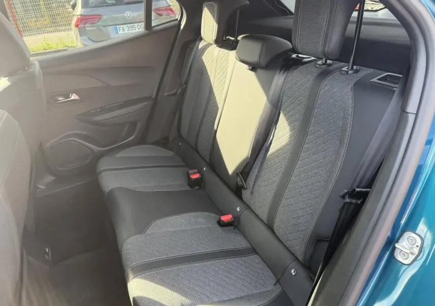 Vue côté droit de la banquette arrière en tissu gris et cuir noir du Peugeot e-2008 Bleu Obsession 2025.