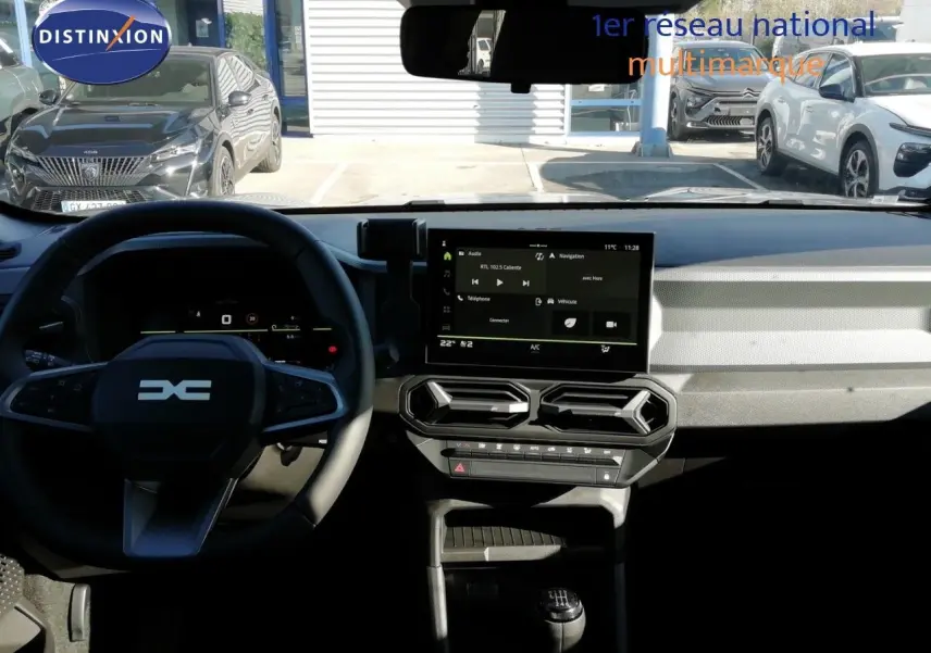 Vue intérieure du tableau de bord du Dacia Duster 2026, avec écran tactile central et volant multifonction noir.