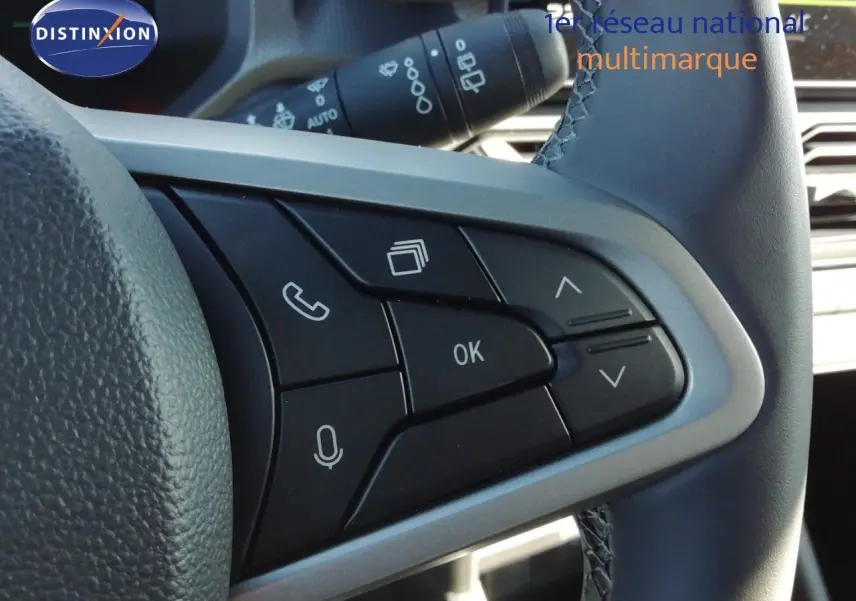 Gros plan sur les commandes multifonctions noires du volant gris du Dacia Duster TCE MHEV 140ch Journey 2026.