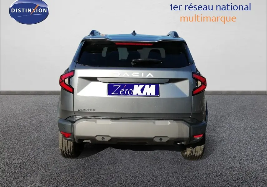 Vue arrière d’un Dacia Duster gris schiste métal 2026 avec feux LED et logo DACIA visible.