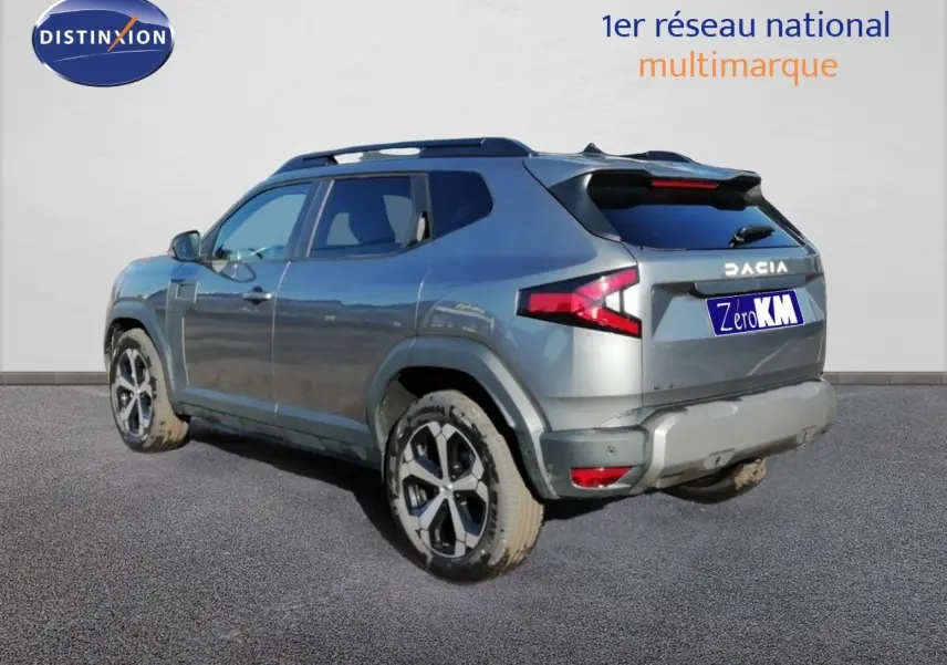 Vue 3/4 arrière droite du Dacia Duster TCE MHEV 140ch Journey gris schiste métal avec jantes biton et feux LED distinctifs.