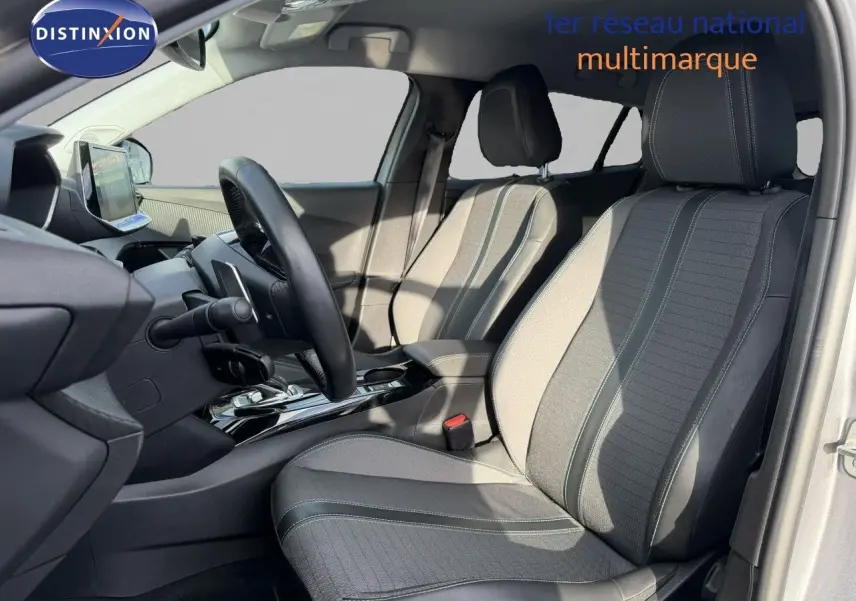 Vue intérieure côté conducteur du Peugeot 2008 gris Artense, mettant en valeur les sièges en tissu et cuir noir.