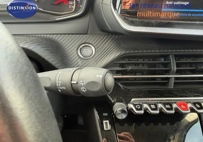Vue intérieure du tableau de bord du Peugeot 2008 gris Artense, avec bouton start/stop et commandes de climatisation visibles.