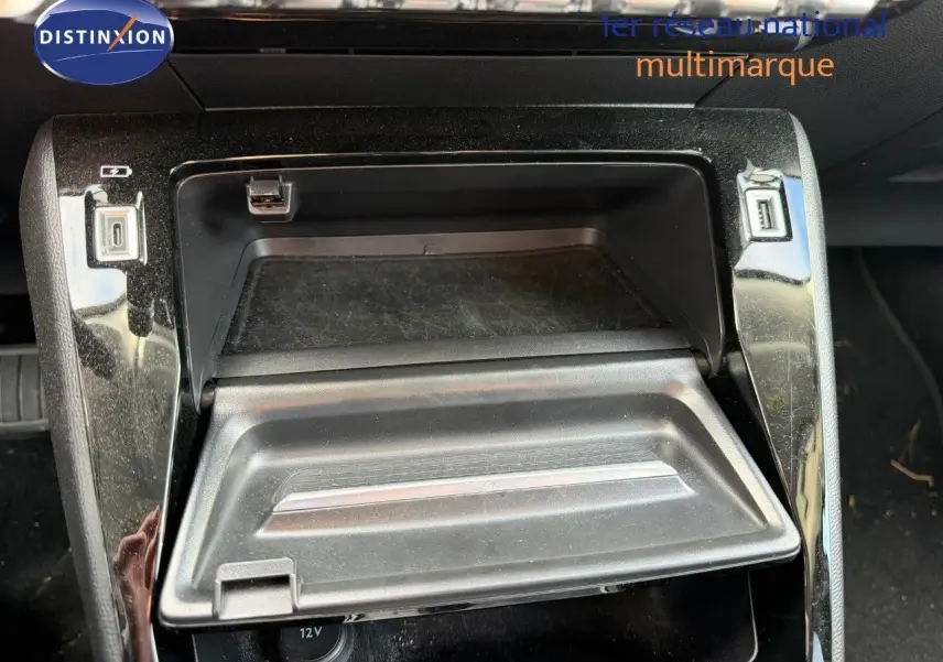 Gros plan sur la console centrale du Peugeot 2008 gris Artense, montrant un compartiment de rangement ouvert avec ports USB.