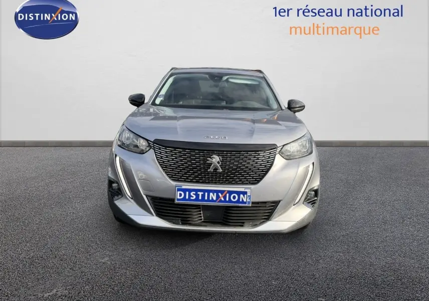 Vue avant d'un Peugeot 2008 gris Artense 2022 avec calandre noire et phares LED allumés.