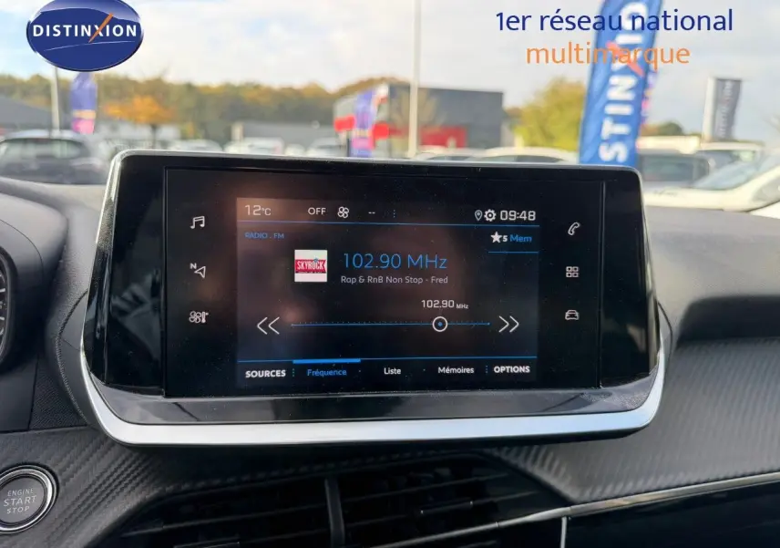 Écran tactile central du tableau de bord du Peugeot 2008 gris Artense, affichant la radio FM à 102,90 MHz.