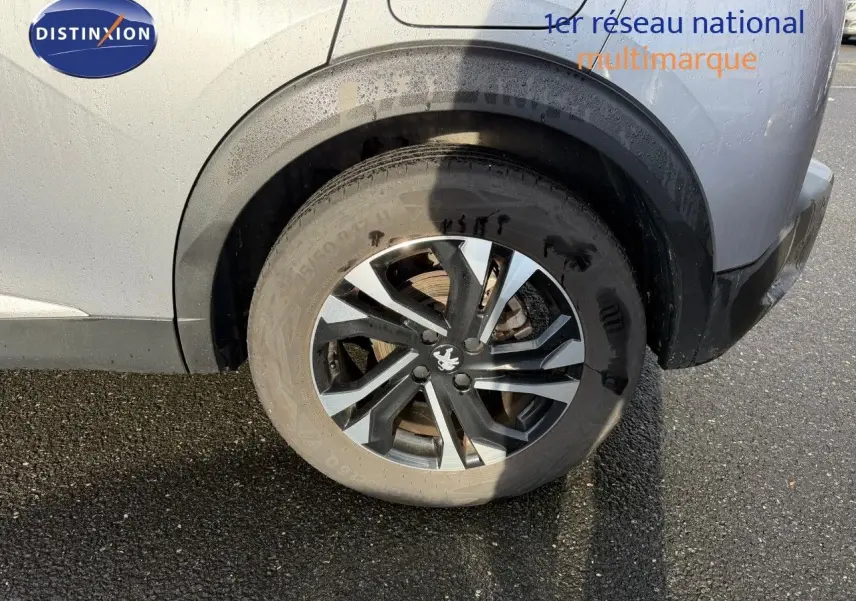 Gros plan sur la roue arrière droite d'un Peugeot 2008 gris Artense, mettant en valeur la jante alliage noire et argentée.