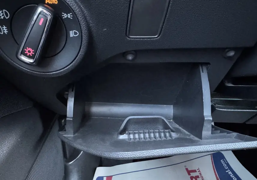 Détail du compartiment de rangement ouvert côté gauche du tableau de bord noir d'une SEAT LEON gris 2016.