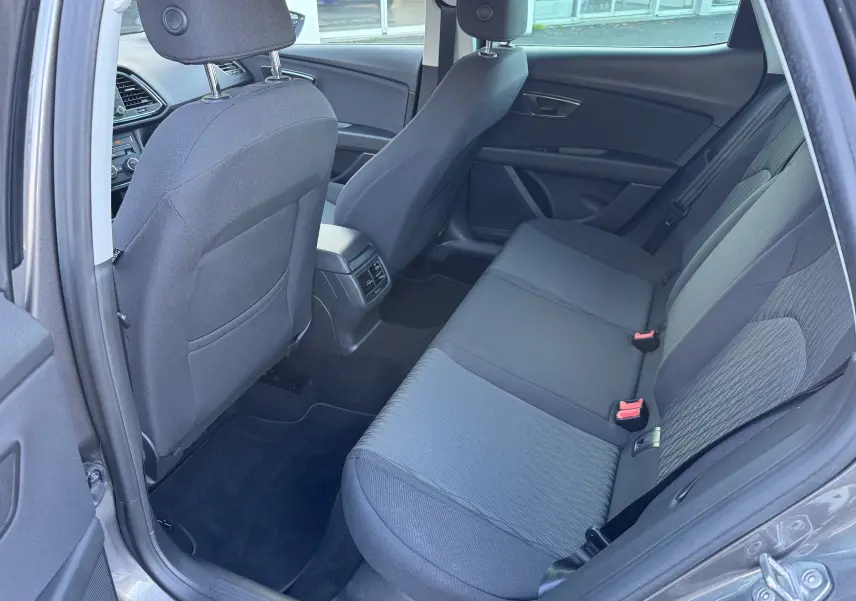 Vue intérieure côté droit sur la banquette arrière grise du SEAT LEON 2016 avec sièges tissu et ceintures visibles.
